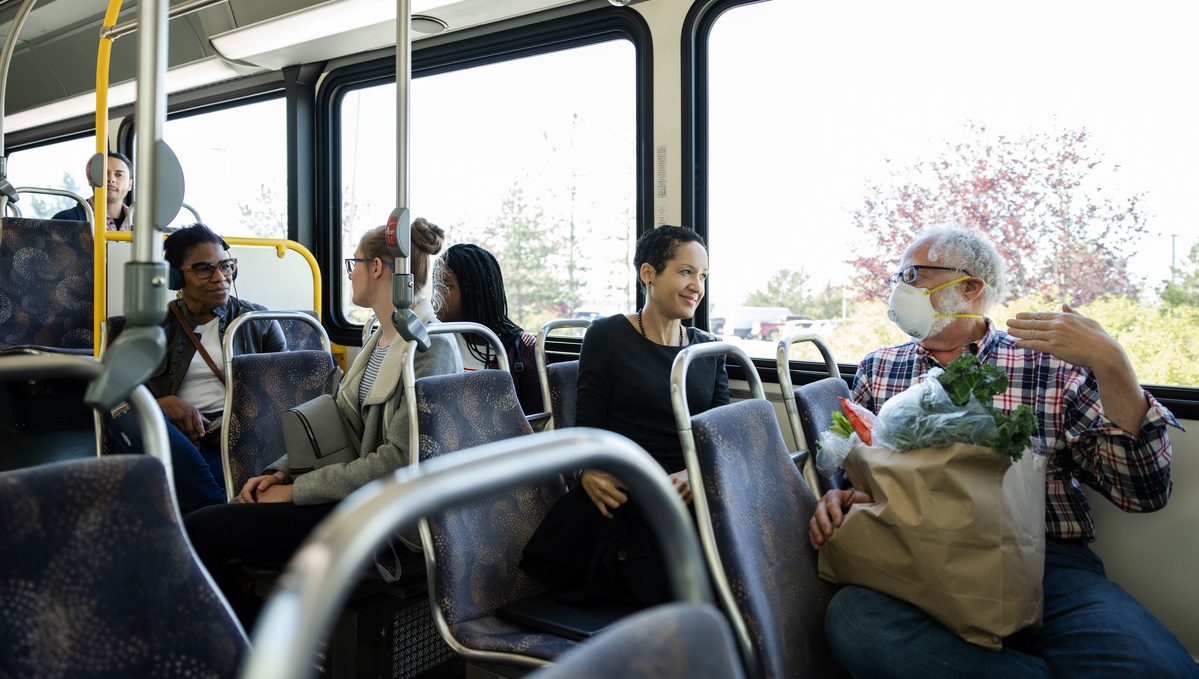 People riding a bus during the day